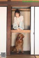 A woman sitting in a wooden box with a dog.